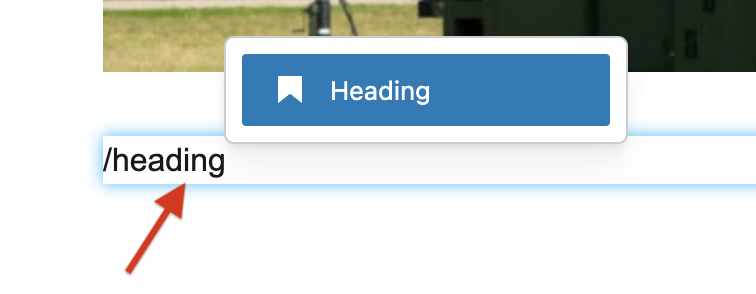 Screenshot of a WordPress page featuring a text box with "/heading" typed, highlighted by a red arrow.