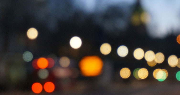 Generic dark image of blurry lights in the distance.