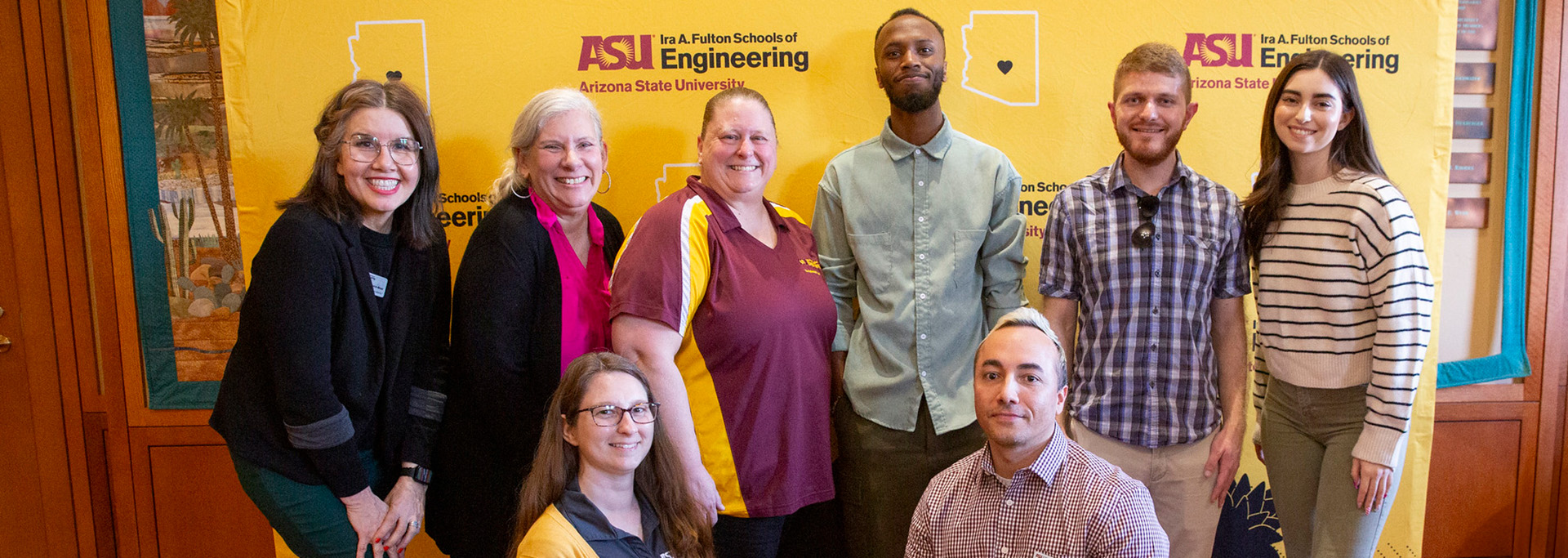 Marketing team members pose together at an event for a group photo.